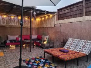an outdoor patio with couches and an umbrella at Antic house in Agadir