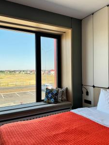 a bedroom with a bed and a large window at Keruen inn Karaganda in Karagandy
