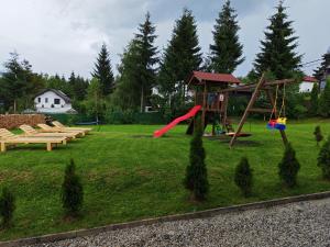 a park with a playground with benches and a slide at Aqualina Colibita - pe malul lacului in Colibiţa