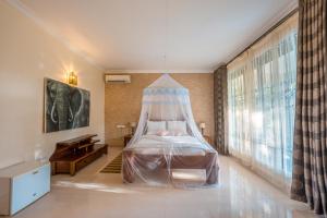 a bedroom with a bed with a mosquito net at Tan-Swiss Inn in Mikumi +41 photos
