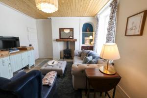 a living room with a couch and a table at Southend Cottage By Birch Stays in Penrith