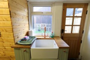 a kitchen with a white sink and a window at Southend Cottage By Birch Stays in Penrith +64 photos