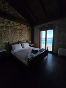 a bedroom with a large bed with a large window at Volakas Beachfront Suites in Rethymno +25 photos