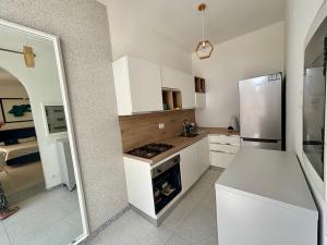 a kitchen with white cabinets and a stove and refrigerator at To Be Capri Sea view Rooms in Capri
