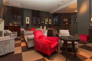 a living room with red chairs and a table at Malmaison Hotel Leeds in Leeds