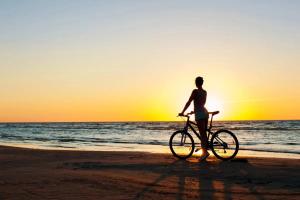 a woman standing on the beach with a bike at Geheimtipp KÖNIGSSTUHL - gratis WLan, Smart TV in Rostock