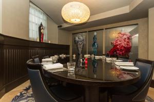a dining room with a table and chairs and a chandelier at Malmaison Hotel Leeds in Leeds