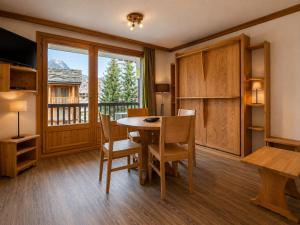 a dining room with a table and chairs and a window at Val d'Isère Centre - Emplacement Idéal in Val-d'Isère
