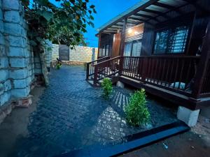 a house with a brick walkway next to a building at Embawwo Rustic Cabin in Entebbe