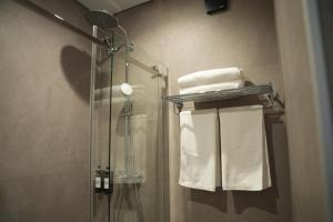 a bathroom with a shower and some towels at Keruen inn Karaganda in Karagandy +23 photos