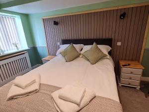 a bedroom with a white bed with two pillows at Moorside Hotel and Cafe in Stoupe Brow +8 photos