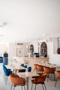 a restaurant with tables and chairs and a kitchen at Domaine de Beaucens in Beaucens