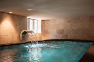 a swimming pool with a water fountain at Domaine de Beaucens in Beaucens