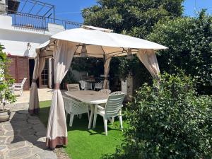 a table and chairs under an umbrella in a garden at B&B IL TULIPANO free private parking in Como