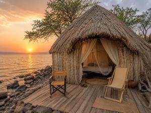 a room with a bed and two chairs in front of the ocean at Fort Banya Resort in Eliye