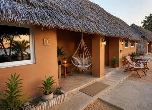 a resort with a hammock hanging from a thatch roof at Fort Banya Resort in Eliye