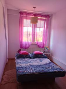 a bedroom with a bed and a window with pink curtains at 3-Pokojowy Apartament Villa Park - Top Location in Olsztyn