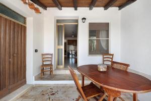 a dining room with a wooden table and chairs at Casa Beccari in Cala Liberotto