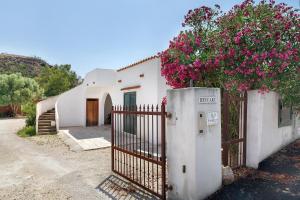 a white house with a gate with flowers on it at Casa Beccari in Cala Liberotto