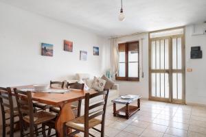 a living room with a wooden table and chairs at Casa Beccari in Cala Liberotto +12 photos
