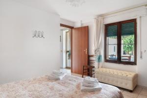 a white bedroom with a bed and a window at Casa Beccari in Cala Liberotto
