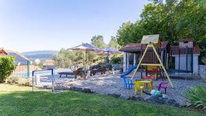 a playground with a slide and benches and umbrellas at Villa Emanuela by Villas Guide in Grubine