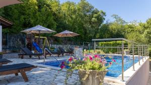a swimming pool with chairs and umbrellas next to at Villa Emanuela by Villas Guide in Grubine
