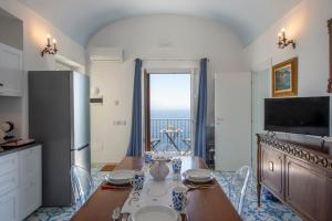 a kitchen with a table and a refrigerator at Villa Alba - Amalfi Coast in Amalfi