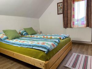 a bedroom with two beds with green sheets and a window at Cabana 84 in Beclean
