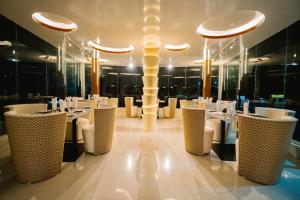 a dining room with white tables and chairs at Royal Hotel Khulna - City Center in Khulna