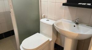 a bathroom with a white toilet and a sink at Hotel Benjamin Naval in Biliran