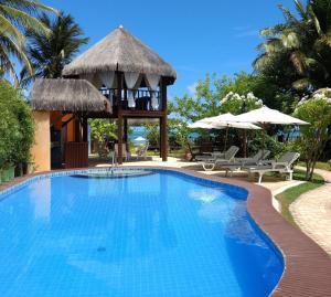 a swimming pool at a resort with a gazebo at Pousada Riacho dos Milagres in São Miguel dos Milagres