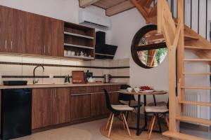 a kitchen with wooden cabinets and a table with chairs at Domki & Jacuzzi w Centrum Soliny 885-053-839 in Solina