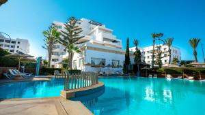 a swimming pool in front of a building at Intouriste Hotel & Suites in Agadir
