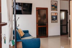 a living room with a blue chair and a door at Domki & Jacuzzi w Centrum Soliny 885-053-839 in Solina