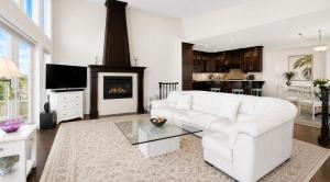 a living room with a white couch and a fireplace at Seaview Executive Home in Ladysmith