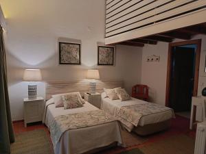 two beds in a hotel room with two lamps at Casa Do Foral in Rio Maior