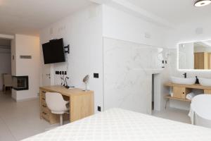a white bedroom with a desk and a bed at Apartments ANA Karlobag in Karlobag +179 photos