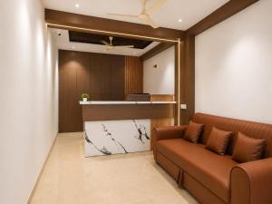 a waiting room with a couch and a counter at The Kingsway Suites in Nagpur