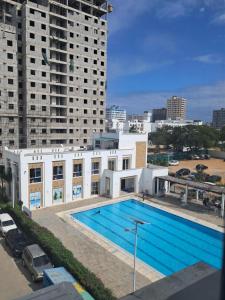 a swimming pool on the roof of a building at Cozy 2 BR with 3 Beds, AC & Hot Shower at Buxton Point Apartments Off RG Road Gate A in Mombasa