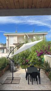 a white umbrella over a table in a patio at Egea Beach House in Lido di Camaiore