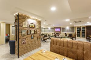 ein Restaurant mit einer Backsteinmauer und Tischen und Stühlen in der Unterkunft Antroyal Hotel in Antalya