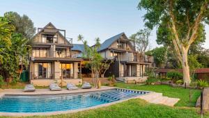 a house with a swimming pool in front of a house at River House Lodge in Malelane
