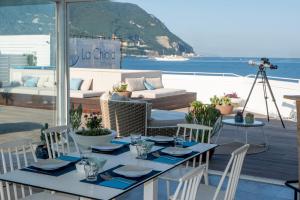 a table and chairs on a patio with a view of the ocean at La Chiaja art&relais in Castellammare di Stabia +57 photos