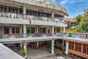 an apartment building with balconies and tables and chairs at Collection O near Museum Pusaka Karo formerly 3 Berastagi in Berastagi