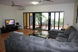 a living room with two couches and a television at Darwin Deluxe Apartments in Darwin