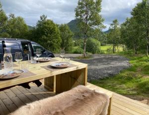 a wooden table with wine glasses on a deck at Hjertero - Hide Away Suite in Sortland