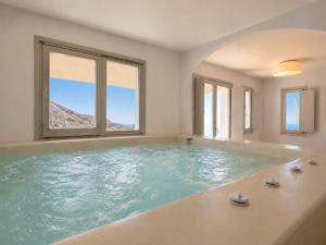 a large bathroom with a large swimming pool at Vespera Private Luxury Suites in Santorini