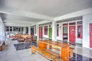 a living room with a wooden bench and tables at Collection O near Museum Pusaka Karo formerly 3 Berastagi in Berastagi +49 photos