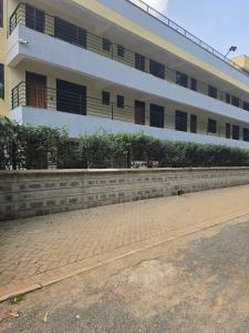 a building with a brick sidewalk in front of it at Crane Suites in Eldoret